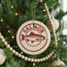 A Christmas tree decorated with ornaments, including a round ornament with a salmon design and the word "Salmon" written on it.