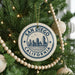 A decorative ornament on a Christmas tree, featuring a circular design with the text "SAN DIEGO CALIFORNIA" and a cityscape illustration.