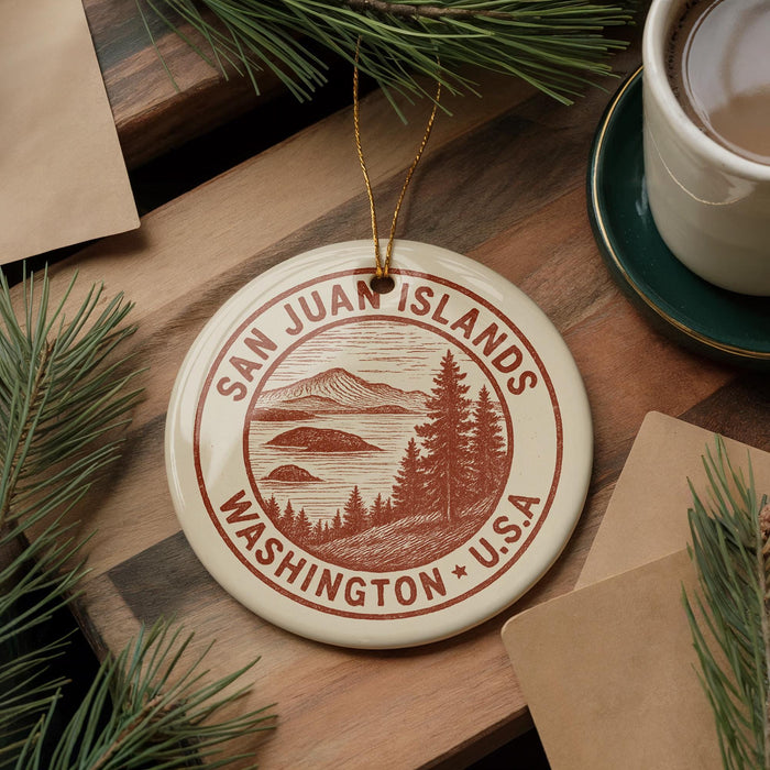 A circular ornament with the text "SAN JUAN ISLANDS WASHINGTON U.S.A." printed on it, surrounded by pine branches and a cup of coffee on a wooden surface.