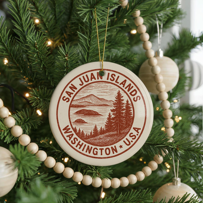 A Christmas tree decorated with ornaments, including a circular ornament with the text "SAN JUAN ISLANDS WASHINGTON *USA" and a wooden bead decoration.