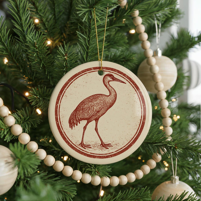 A Christmas tree decorated with ornaments, including a circular ornament featuring a red bird silhouette.