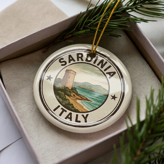 A decorative ornament in a box, featuring a lighthouse and the text "SARDINIA ITALY".