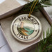 A decorative ornament in a box, featuring a lighthouse and the text "SARDINIA ITALY".