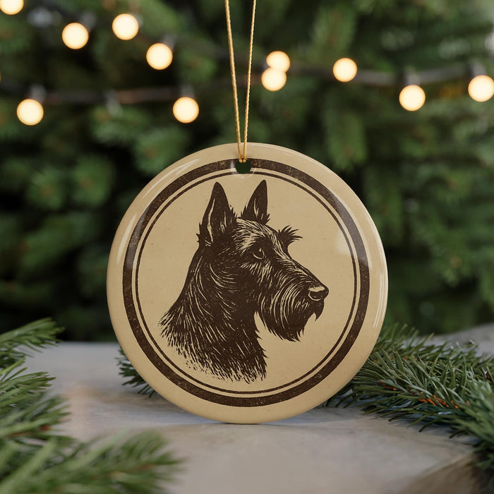 A circular ornament featuring a black and white illustration of a dog's head is displayed in front of a blurred background of Christmas lights.