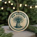 A circular ornament with the text "SEA ANEMONE" and an illustration of an anemone is displayed in front of a blurred Christmas tree with lights.