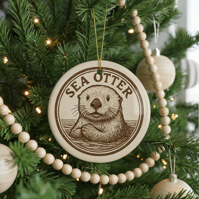 A Christmas tree decorated with ornaments, including a circular ornament with a picture of a sea otter and the text "SEA Otter" on it.