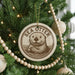 A Christmas tree decorated with ornaments, including a circular ornament with a picture of a sea otter and the text "SEA Otter" on it.
