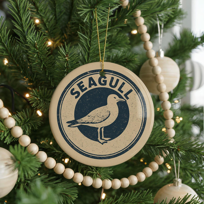 A Christmas tree decorated with ornaments, including a round ornament with the word "Seagull" and a wooden bead decoration.