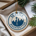 A decorative ornament with the text "SEATTLE WASHINGTON" and a silhouette of the Space Needle, hanging from a string.