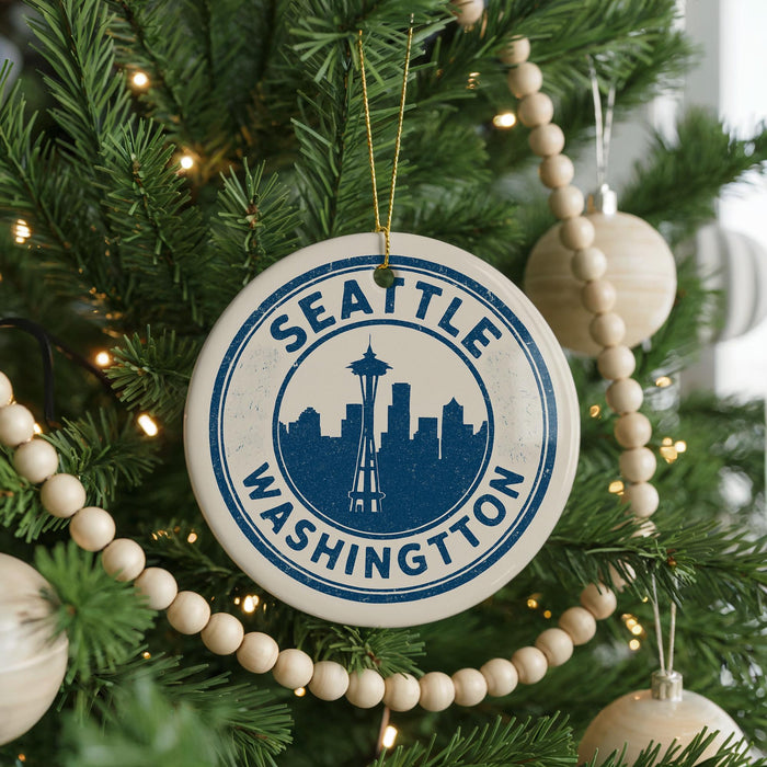 A Christmas tree decorated with ornaments, including a circular ornament with the text "SEATTLE WASHINGTON" and a silhouette of the Space Needle.