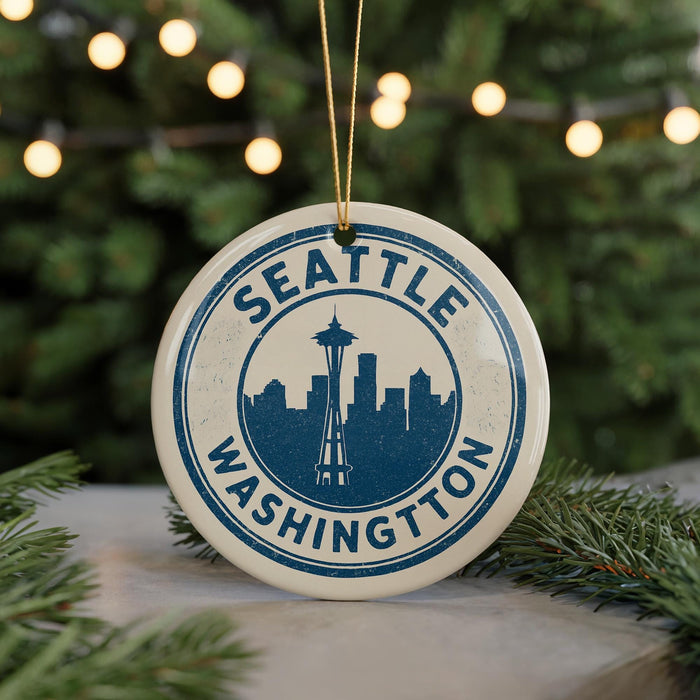 A circular ornament with the text "SEATTLE WASHINGTON" and a silhouette of the Space Needle in the center, hanging from a string.