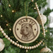 A circular ornament with a brown and white design hangs from a Christmas tree, featuring a dog's face and the text "SHAR PEI".