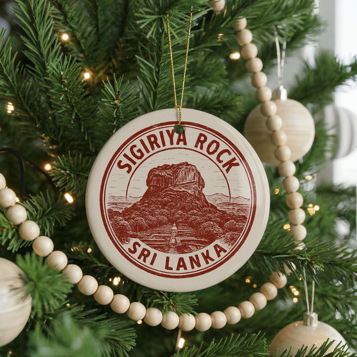 A Christmas tree decorated with ornaments, including a circular ornament with the text "SIGIRIYA ROCK" and "SRI LANKA" printed on it.