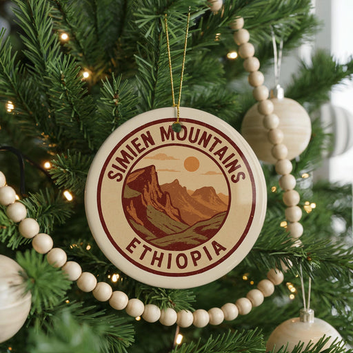 A Christmas tree decorated with ornaments, including a circular ornament with the text "SIMIEN MOUNTAINS ETHiopia" and a wooden bead decoration.
