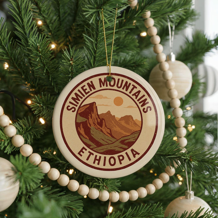 A Christmas tree decorated with ornaments, including a circular ornament with the text "SIMIEN MOUNTAINS ETHiopia" and a wooden bead decoration.