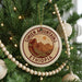 A Christmas tree decorated with ornaments, including a circular ornament with the text "SIMIEN MOUNTAINS ETHiopia" and a wooden bead decoration.