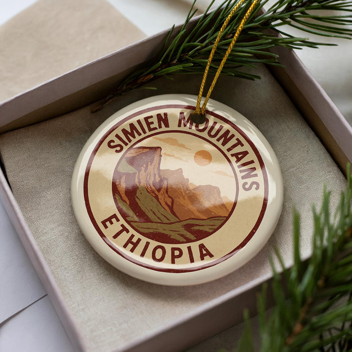 A circular ornament with the text "SIMIEN MOUNTAINS ETHIOPIA" printed on it, surrounded by pine branches.
