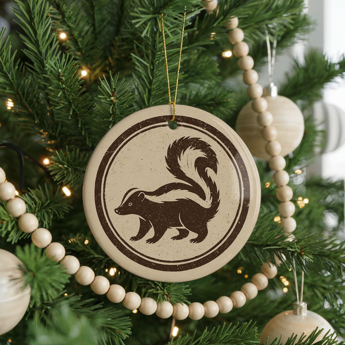 A Christmas tree decorated with ornaments, including a round ornament featuring a skunk silhouette.