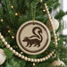 A Christmas tree decorated with ornaments, including a round ornament featuring a skunk silhouette.