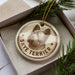 A circular ornament featuring a Skye Terrier dog's head, with the text "SKYE TERRIER" printed on it, is displayed in a box surrounded by pine branches.
