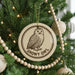 A Christmas tree decorated with ornaments, including a circular ornament featuring a snowy owl.