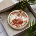 A round ornament with a monkey image and the text "SNUB-NOSED MONKEY" is displayed in a box, surrounded by pine branches.