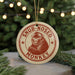 A round ornament with a monkey image and the text "SNUB-NOSED MONKEY" printed on it, hanging from a string.