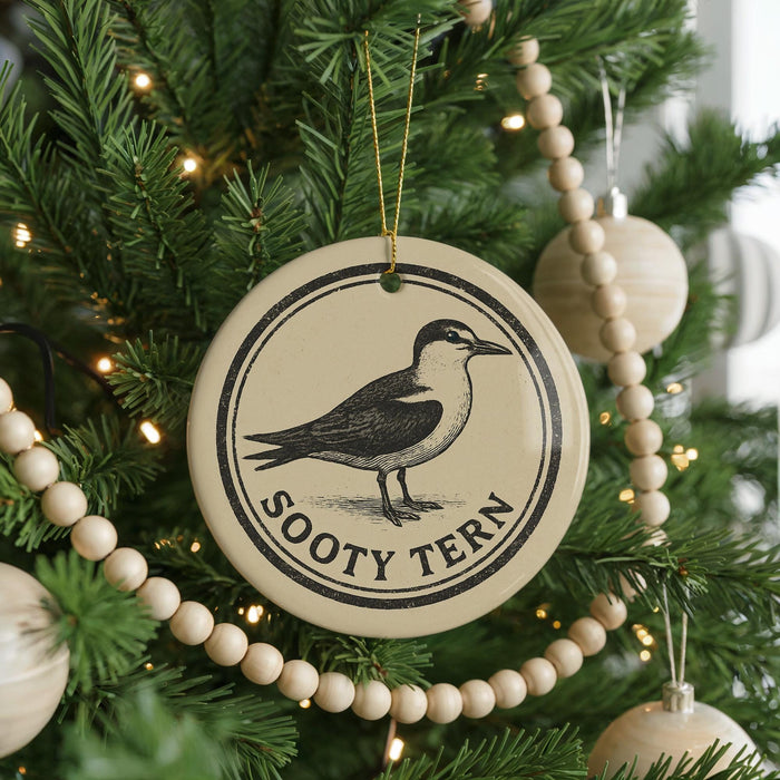 A Christmas tree decorated with ornaments, including a circular ornament with a bird image and the text "Sooty Tern" on it.