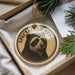 A round ornament with a bear image and the text "SPECTACLE BEAR" is displayed in a box, surrounded by pine branches.