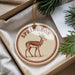 A decorative ornament featuring a deer or antelope, with the text "SPRINGBOK" printed on it, is displayed in a box with pine branches.