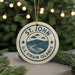 A circular ornament with the text "ST. JOHN U.S. VIRGIN ISLANDS" and a graphic of a mountain and ocean, hanging from a string.