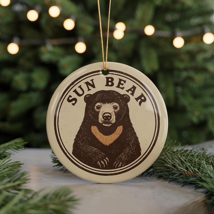 A circular ornament featuring a bear image with the text "SUN BEAR" around it, hanging from a string.