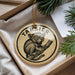 A circular ornament with a monkey sitting on a branch, surrounded by greenery.