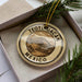 A circular ornament with the text "TEOTÍUACÁN MEXICO" printed on it, surrounded by pine branches.