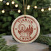A circular ornament with the text "TIANJIN CHINA" and a graphic of a city skyline, hanging from a string.