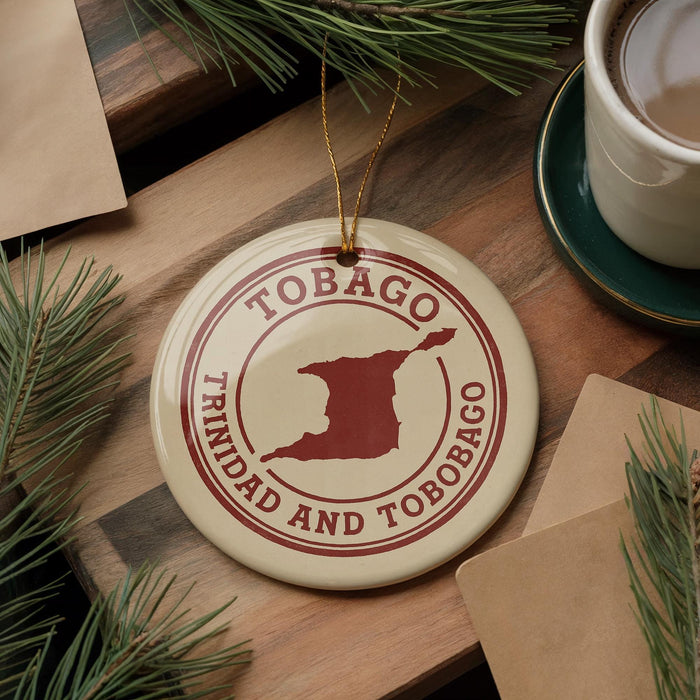 A circular ornament with the text "TOBAGO TRINIDAD AND TOBAGO" printed on it, along with a map of Trinidad and Tobago, is displayed on a wooden surface.