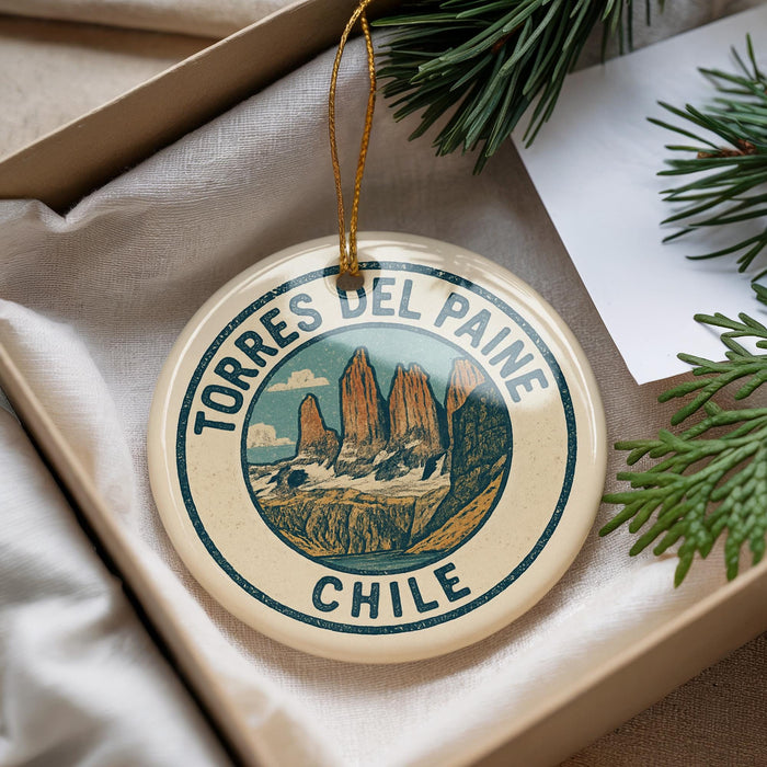 A decorative ornament with the text "TORRES DEL PAINE CHILE" on it, featuring a mountain landscape design.
