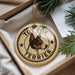 A round ornament with a dog's head and the text "TOY FOX TERRIER" printed on it, hanging from a string.