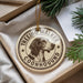 A circular ornament with a dog's head and the text "TREEPING WALKER COONHOUN" printed on it, hanging from a string.