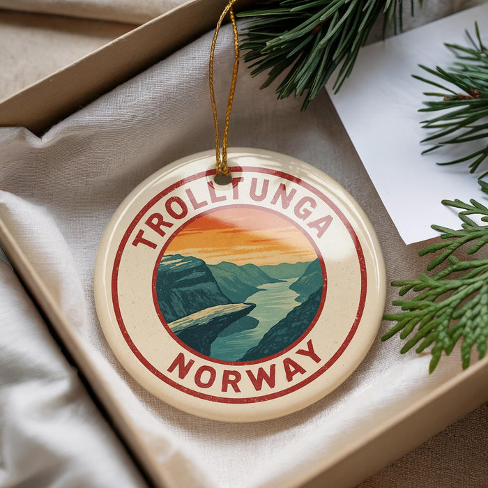 A round ornament with the text "TROLLTUNGA NORWAY" and an illustration of a mountain landscape hangs from a string.