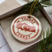 A circular ornament with the word "TURKEY" and a map of Turkey, placed inside a box with pine branches.