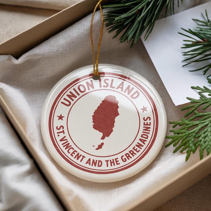 A round ornament with the text "UNION ISLAND" and a map of St. Vincent and the Grenadines, along with a pine branch, is displayed in a box.