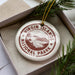A white ornament with a red border and the text "VIRGIN ISLANDS NATIONAL PARK U.S.A." is displayed in a box, surrounded by pine branches.
