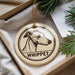 A round ornament with a dog's head and the word "WHIPPET" printed on it, hanging from a string.