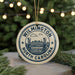 A circular ornament with the text "WILMINGTON NORTH CAROLINA" and an illustration of a bridge, hanging from a string.