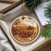A circular ornament with the text "WIND CAVE NATIONAL PARK USA" printed on it, surrounded by a landscape of mountains and pine trees.