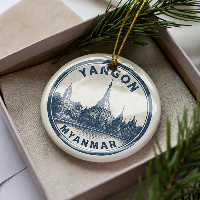 A decorative ornament in a box, featuring a circular design with a picture of a temple and the text "YANGON MYANMAR".