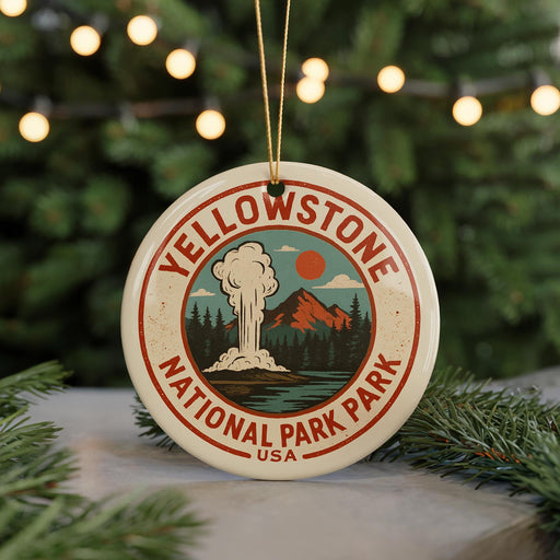 A circular ornament with the text "Yellowstone National Park" and an illustration of a mountain, steam, and pine trees, hanging from a string.