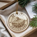 A decorative ornament with the text "ZERMATT SWITZERLAND" and a mountain illustration, hanging from a string.