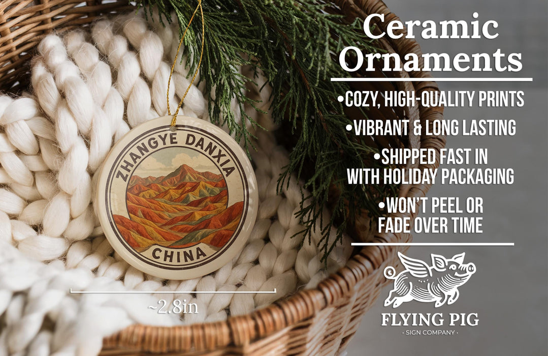 Ceramic ornaments, featuring a round ornament with a mountain landscape design, are displayed in a woven basket.